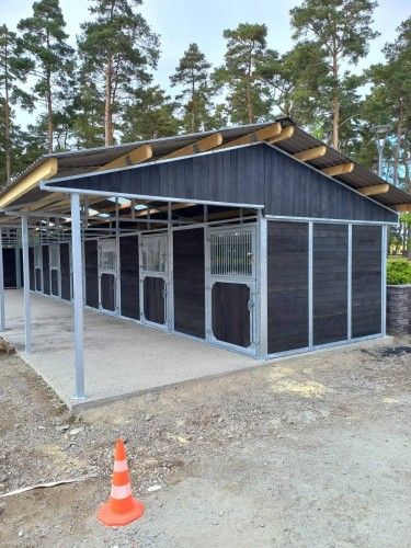 Wiata stajenna z boksami, ściany obłożone deskami kompozytowymi EKOFORME w kolorze czarnego dębu